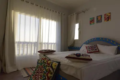 a bedroom with a bed with pillows and a window at Lagoon View Penthouse - El Gouna Paradise Escape in Hurghada