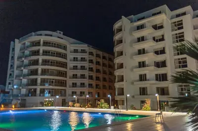 a hotel with a swimming pool in front of a building at The Comfortable palace in Hurghada