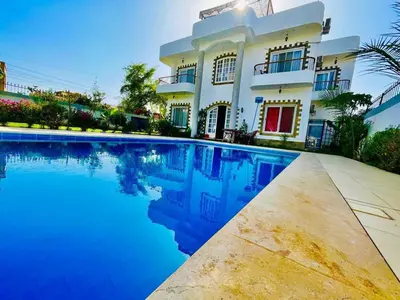 a house with a swimming pool in front of it at Ali Luxury Villa in Luxor