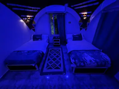 a bedroom with two beds in a blue room at Noura hasel nubian house in Aswan