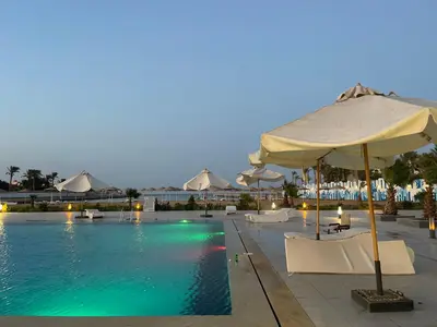 a swimming pool with umbrellas and chairs and a pool at شقة علي البحر 2 in Hurghada