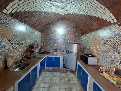 a kitchen with blue cabinets and a white refrigerator at Mostafa Nubian Guesthouse in Najâ€˜ al MadÄbb
