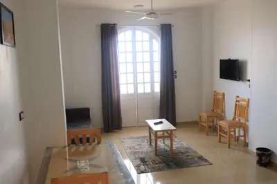 a living room with a table and chairs and a window at Royal Mountain in Luxor