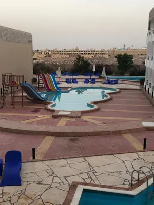 a large pool with chairs and a slide at Cecelia resort in Hurghada