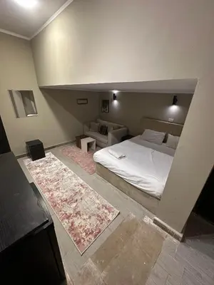 a bedroom with a large bed and a couch at Cheapest studio at El-Gouna - Bali compound in Hurghada