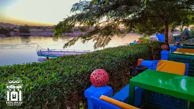 a table and chairs next to a body of water at Kato Waidi Nubian Resort in Aswan