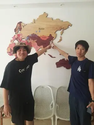 two young men standing in front of a world map at Lamera Hotel in Hurghada