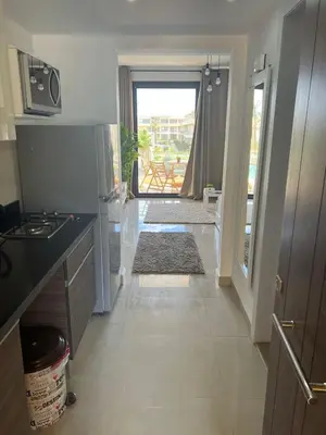 a kitchen with a counter and a door to a balcony at Cozy studio in G cribs in Hurghada