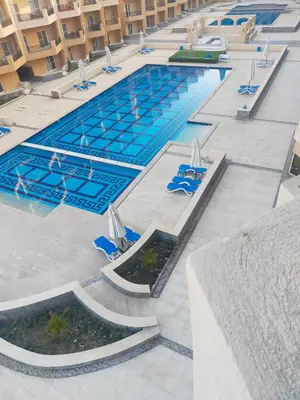 an overhead view of a swimming pool with blue chairs at Red Sea Panorama in Hurghada