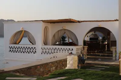 a white house with arches and a table and chairs at Noprea Boutique Hotel in Aswan
