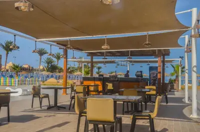 a restaurant with tables and chairs and the beach at Scandic resort in Hurghada