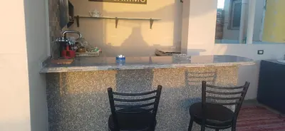 a kitchen with three chairs and a counter with a counter top at Sunny sky in Quseir
