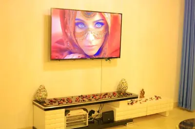 a television hanging on a wall with a woman on it at Sun Of Marina in Hurghada