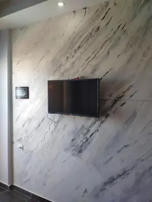a flat screen tv hanging on a marble wall at سيسيليا اتش in Hurghada