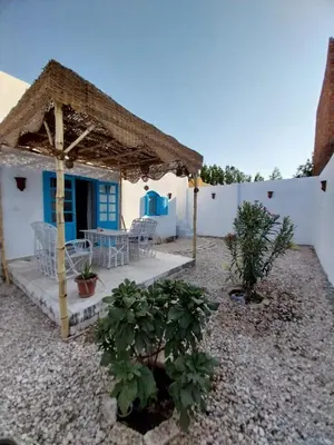 a small white house with a table and chairs at desert pearl beautiful cosy new home in Luxor