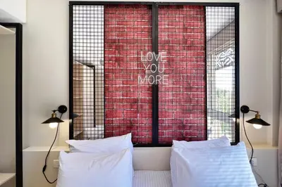 a bedroom with two pillows and a red brick wall at Rugged & Relaxed 1 BDR Mangroovy Free Pool & Beach Access in Hurghada