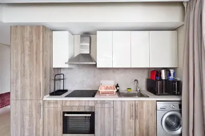 a kitchen with white cabinets and a sink at Rugged & Relaxed 1 BDR Mangroovy Free Pool & Beach Access in Hurghada