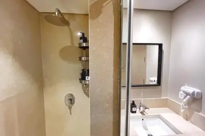 a bathroom with a shower with a sink and a mirror at Enticing & Earthy 1 BDR Mangroovy Free Pool & Beach Access in Hurghada