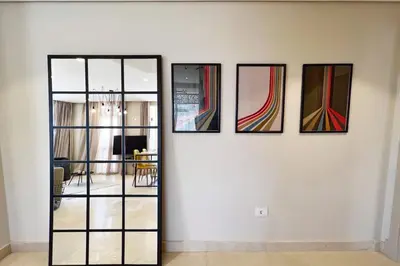 a group of four paintings on a white wall at Enticing & Earthy 1 BDR Mangroovy Free Pool & Beach Access in Hurghada