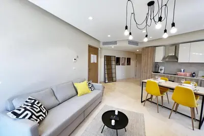 a living room and kitchen with a couch and a table at Enticing & Earthy 1 BDR Mangroovy Free Pool & Beach Access in Hurghada