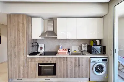 a kitchen with white cabinets and a washer and dryer at Enticing & Earthy 1 BDR Mangroovy Free Pool & Beach Access in Hurghada