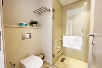 a bathroom with a toilet and a shower with a towel at Proper & Plush 1 BDR Mangroovy Free Pool & Beach Access in Hurghada