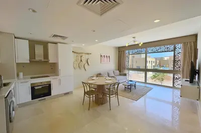 a kitchen and living room with a table and chairs at Perky 1 BDR Mangroovy Free Pool & Beach Access in Hurghada