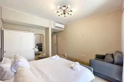 a bedroom with a white bed and a couch at Modern & Mellow 1 BDR Mangroovy Free Beach & Pool Access in Hurghada