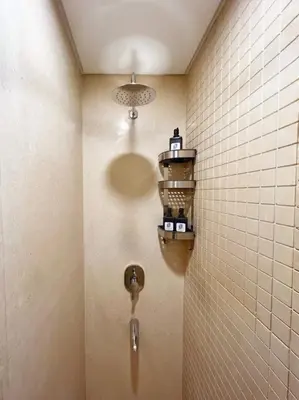 a bathroom with a urinal with a light on the wall at Spectacular & Soaring 2 BDR w Private Rooftop Jacuzzi & Beach Access in Hurghada