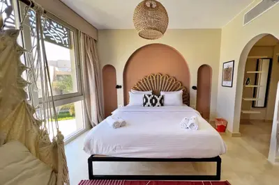 a bedroom with a large bed with a large window at Spectacular & Soaring 2 BDR w Private Rooftop Jacuzzi & Beach Access in Hurghada