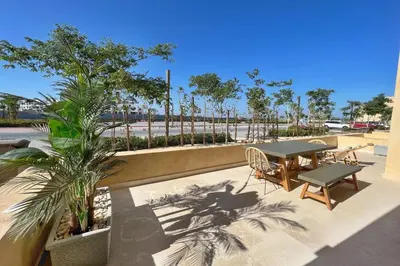 a patio with a table and chairs and palm trees at Sparky & Summery 2 BDR Mangroovy Free Beach & Pool Access in Hurghada