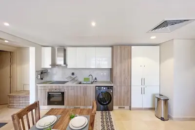 a kitchen with a table and a washer and dryer at Sparky & Summery 2 BDR Mangroovy Free Beach & Pool Access in Hurghada