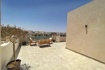 a patio with a table and a bench on a balcony at Radiant & Ravishing 2 BDR Mangroovy Free Beach & Pool Access in Hurghada