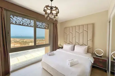 a bedroom with a bed with a view of the beach at Charming 2BDR w Sea & Pool View Free Beach & Pool Access in Hurghada
