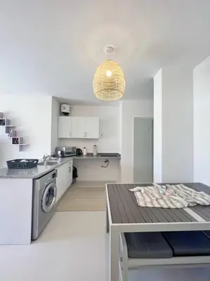 a kitchen with a washer and dryer and a table at Lagoonfront Easy 1BDR Swan Lake El Gouna in Hurghada