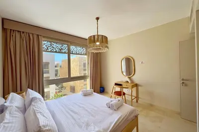a bedroom with a bed and a large window at Dazzling 2 BDR w Rooftop Mangroovy Free Pool & Beach Access in Hurghada
