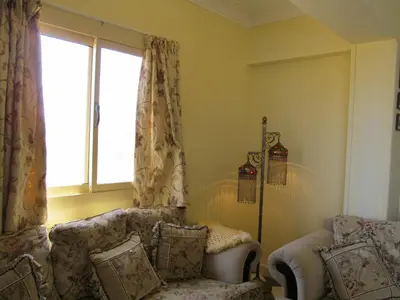 a living room with two chairs and a window at A Beautiful, Family-owned Penthouse Apartment, Overlooking the Red Sea Hurghada in Hurghada