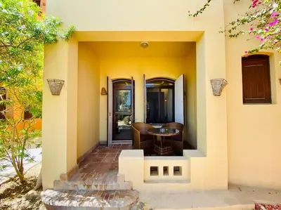 a house with a patio with a table and chairs at Brand New 1-BR Apt @West Golf- El Gouna W/ a View! in Hurghada