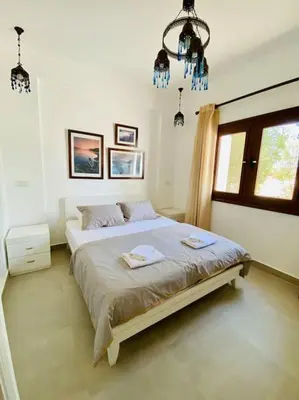 a bedroom with a bed and a chandelier at Brand New 1-BR Apt @West Golf- El Gouna W/ a View! in Hurghada