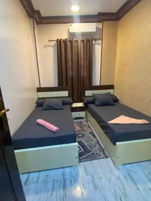 two beds sitting in a room with at Sunrise shiny Nubian Guest House in Aswan