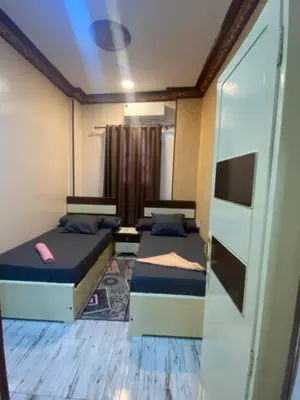 a bedroom with two beds and a sliding glass door at Sunrise shiny Nubian Guest House in Aswan