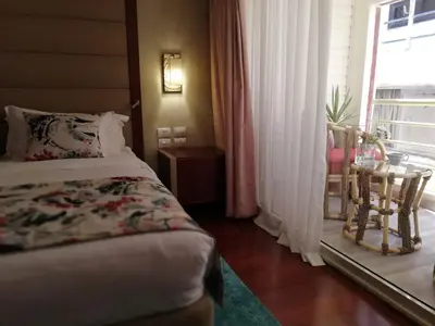 a bedroom with a bed and a table and a window at Nile Cruise 3 nights From Aswan to Luxor Every Friday, Monday and Wednesday with tours in Jazīrat al ‘Awwāmīyah