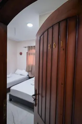 a wooden door in a room with a bed at Kana Kato in Aswan