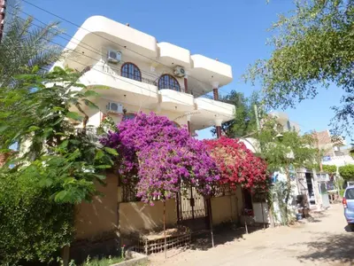 a building with purple flowers on the side of it at Nile View Panoramique and Garden West bank in Luxor