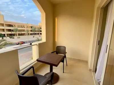a balcony with a table and chairs and a window at Florenza khamsin aprt F7 in Hurghada