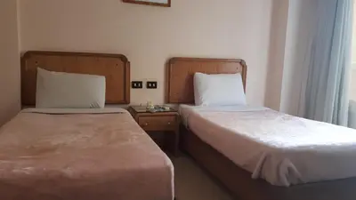 a hotel room with two beds and a window at New Pola Hotel in Luxor