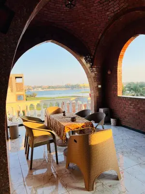 a dining room with a table and chairs in a building at Villa Set ma'at Nile view in Luxor