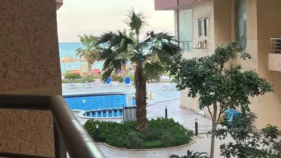 a view of a resort with a pool and palm trees at Casablanca beach resort, first line, with private beach and swimming pools,hurghada in Hurghada