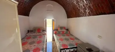 a room with two beds in a room with an arch at Casablanca Guest House in Aswan