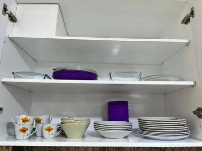 a white shelf with dishes and bowls and plates at GRACELAND Apartment in Hurghada city centre in Hurghada